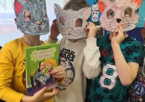 Trzech chłopców w maskach kotów.