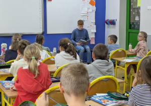 Michał z 8b czyta młodszym kolegom.