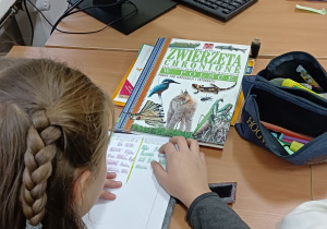 Praca uczniów z atlasami zwierząt.
