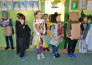 Dzieci przebrane w stroje z papieru, plastikowych worków i zakrętek od butelek.