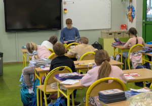 Michał z 8b czyta młodszym kolegom.